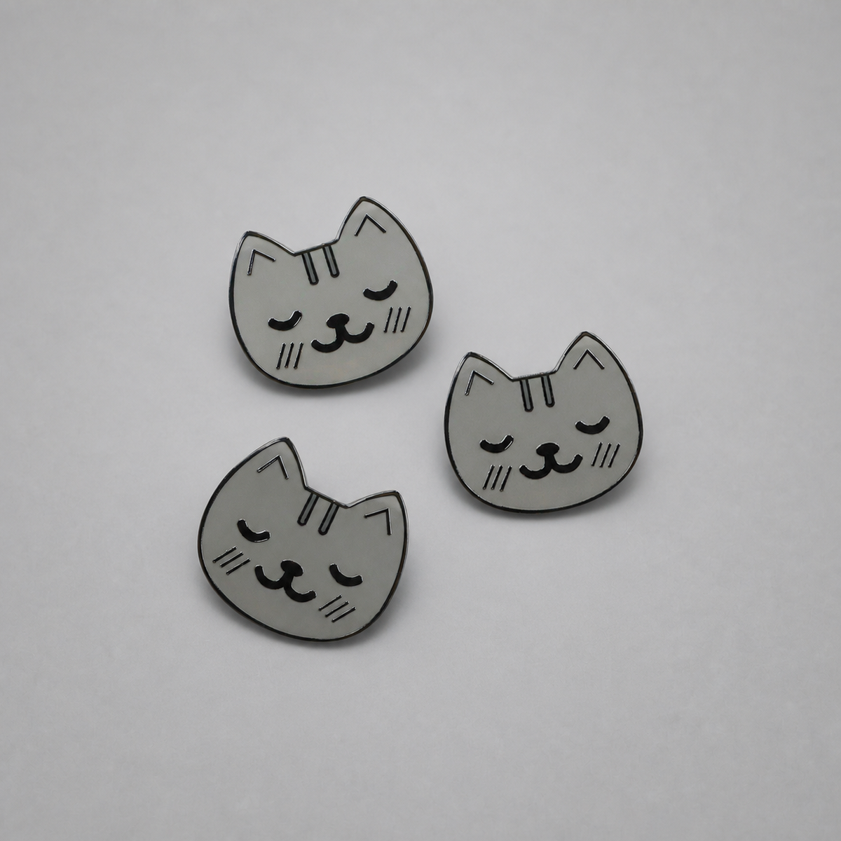 KnT kitty pin set on neutral studio gray background